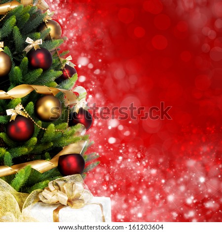 Magically decorated Fir Tree with balls, ribbons and garlands on a blurred Christmas-red shiny, fairy and sparkling background