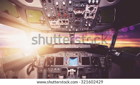Aircraft interior, cockpit view inside the airliner. Point of view from a pilot place in a plane. Sunny sky horizon view from an airplane front glass.