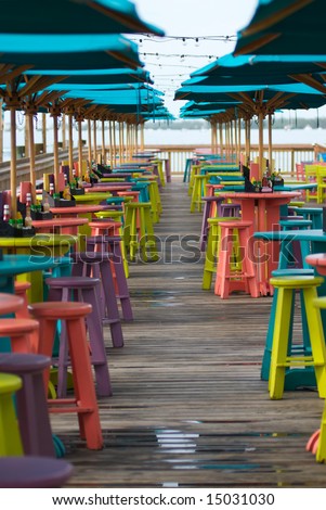 Colorful bar tables, stools and umbrellas at a beach-side bar and restaurant