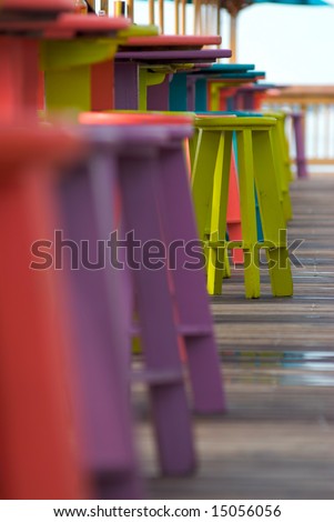Colorful bar stools in a tropical outdoor bar and restaurant with a selective, shallow focus