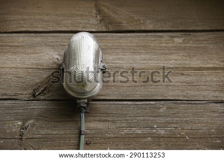 Old lamp on wooden wall with place for the text.