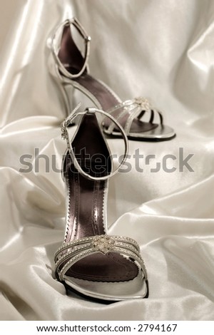 high heel sandals on the white satin
