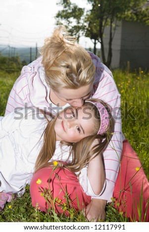 mother kissing her daughter at the park