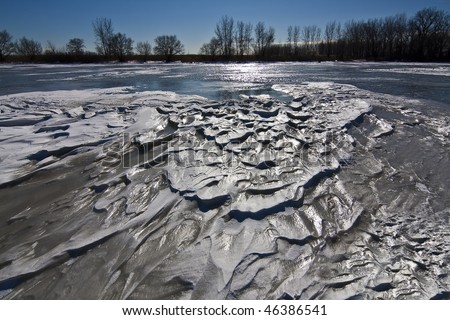 Snow banks on the surface of the frozen lake.