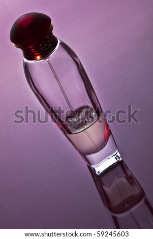 Generic bottle of perfume on a violet reflexive surface.