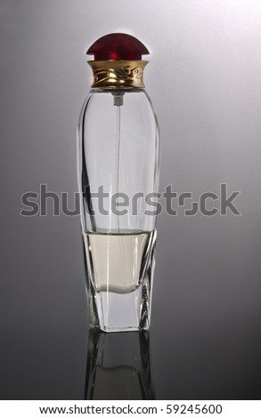 Generic bottle of perfume on a white reflexive surface.