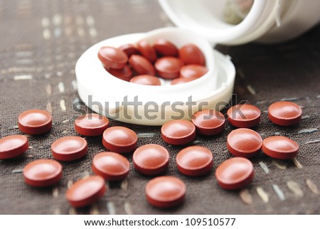 Vitamin pills an pill bottle on white background
