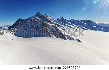 Swiss Aletch glacier helicopter view in winter under bright sunshine