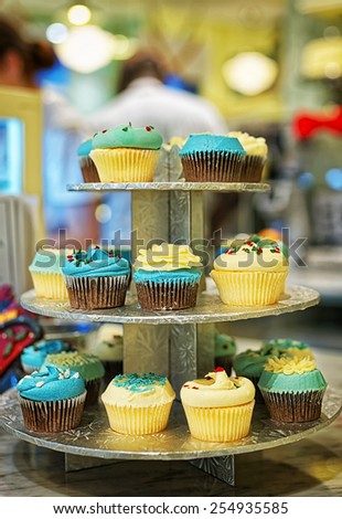 Assorted colored cupcakes on the bakery storefront with blurred background