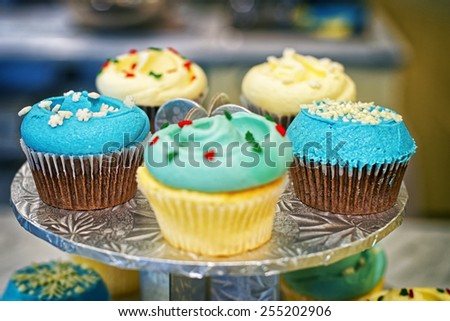 Cupcakes on the round stand at bakery storefront with blurred background