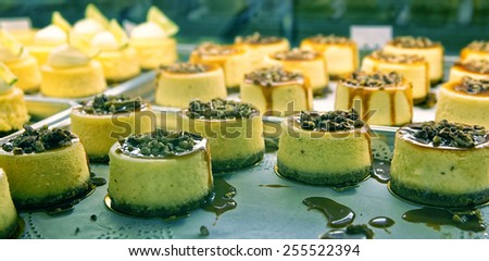Cheesecake with nuts  and liquid caramel on the bakery storefront with blurred background