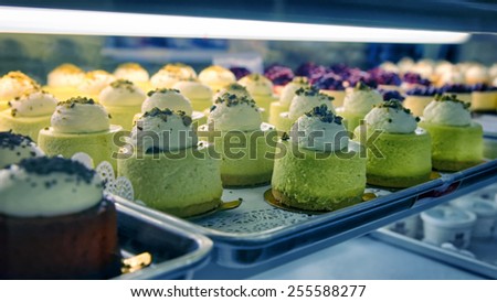 Assorted chesecakes on the bakery storefront with blurred background