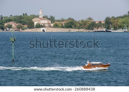Civil motorboat in front of Lido island waterfront in summer Venice