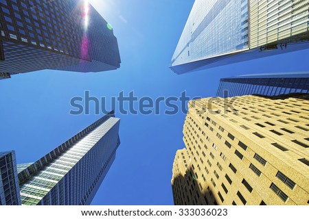 NEW YORK CITY, USA - APRIL 25, 2015: Skyscrapers rising up to sky on Lower Manhattan including the Freedom Tower, New York City, USA. View with picturesque sunlight flares.