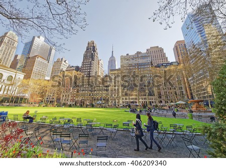 Tourists looking at Green Lawn and Skyscrapers in Bryant Park in Midtown Manhattan, New York, USA.