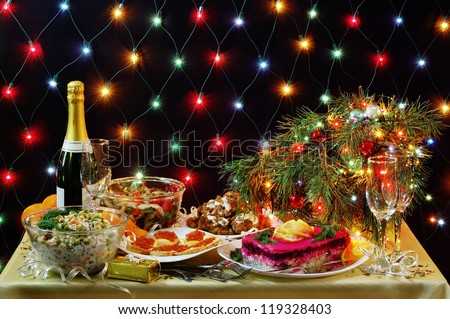 New Year dinner in the Russian tradition with lights in the background.