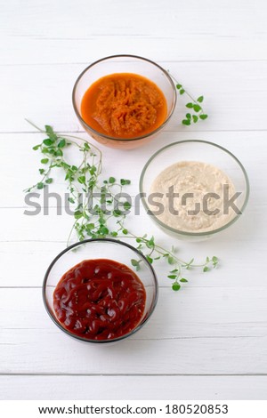 Various kinds of sauces on white wooden background vertical format.
