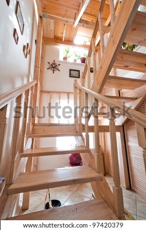 Wooden stairs inside house, colored beige with paintings on walls