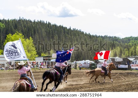 WATER VALLEY, CANADA - JUN 6 2015: Unidentified flag bearers opens the  Bucking Horse Competition in Water Valley. This annual event is important in the rural as well as the sport loving community.
