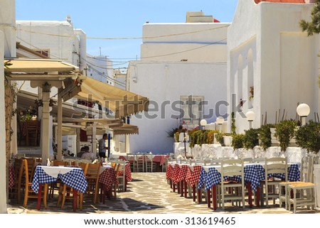MYKONOS ISLAND, GREECE- MAY 24 2014:Typical Greek traditional village with restaurant  with white walls and colorful doors, windows and balconies on Mykonos Island, Greece, Europe