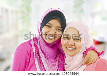 Happy Muslim women standing inside house