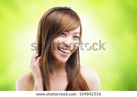 Hair care. Cheerful Asian female combing her hair using finger