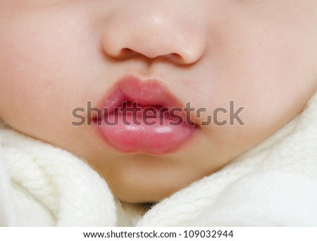 Close up pink lips of a sleeping baby boy with tongue sticking out