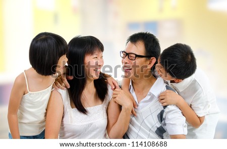 Happy Asian family at home sharing their story