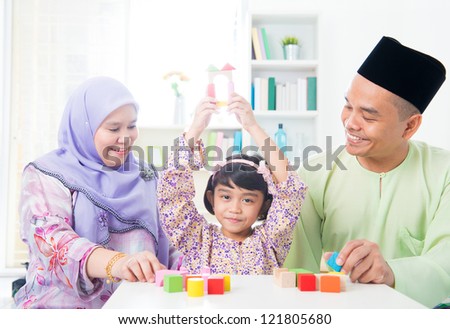 Southeast Asian child achievement. Muslim family playing games.
