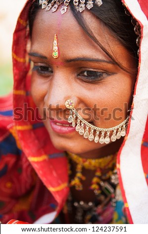 Young Traditional Indian woman in sari costume covered her head with veil, India