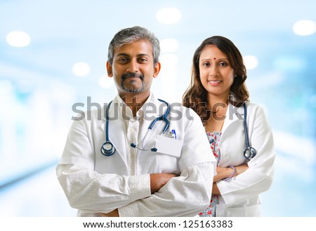 Indian doctors or medical team crossed arms standing, hospital background
