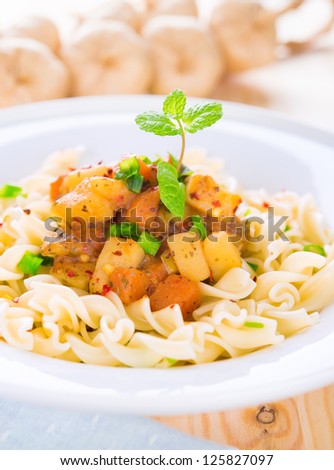 Pasta fusilli with potatoes, carrot and tomatoes on the kitchen table