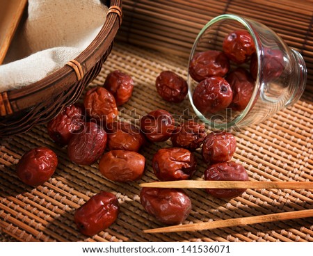 Dried red date or Chinese jujube. Traditional herbal medicine spill on bamboo mat.