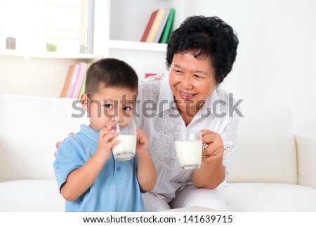 Drinking milk. Happy multi generations Asian family drinking milk at home. Beautiful grandmother and grandson,  healthcare concept.