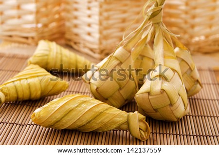 Ketupat or packed rice dumpling. Delicious traditional Malay ramadan food. Popular Malaysian food on bamboo mat.
