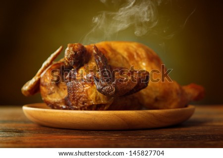 Whole roasted chicken, fresh from oven with heat steam.