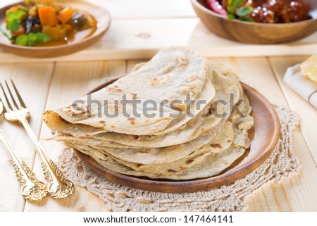 Chapatti roti or Flat bread, curry chicken and dhal. Indian food on dining table.