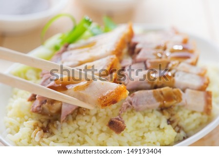 Siu Yuk - Chinese roasted pork served with soy and hoisin sauce. Hong Kong cuisine. Close up on meat and chopsticks.