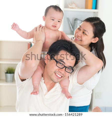 Portrait of Asian parents and six months old baby girl playing at home.