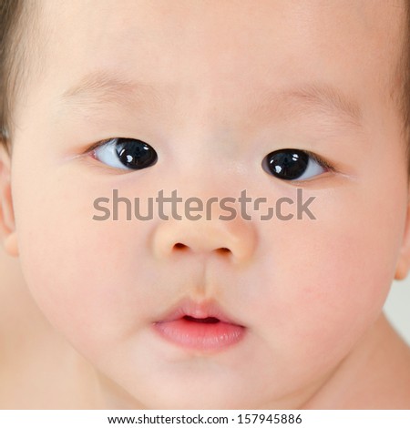 Close up face of Asian baby boy with curious look