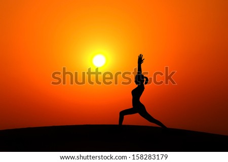 Silhouette Of Woman Doing Yoga Meditation During Sunset With Natural Golden Sunlight On Mountain.