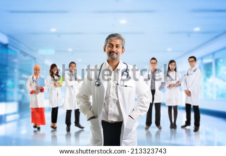 Multiracial diversity Asian medical team, expertise senior and mature doctors leading young practitioners, standing inside hospital.