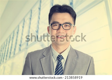 Vintage old style fashion Asian Chinese businessman portrait smiling, office background.