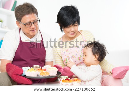 Asian family baking cake, grandparents and grandchild indoor living lifestyle at home.