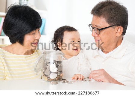 Asian family saving money indoor, financial concept, grandparents and grandchild living lifestyle at home.