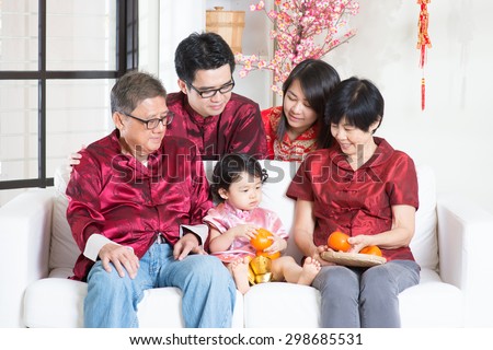 Chinese new year festival. Happy Asian multi generations family in red cheongsam reunion at home.