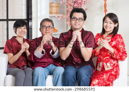 Happy Chinese new year. Happy Asian family in red cheongsam reunion and greeting at home.