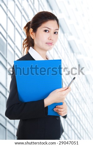 Education / business people. Young Business Women holding file standing in front building block.