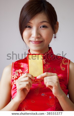 Happy Chinese New Year. Oriental girl in cheongsam wear holding a Chinese red packet wishing you happy Chinese New Year.