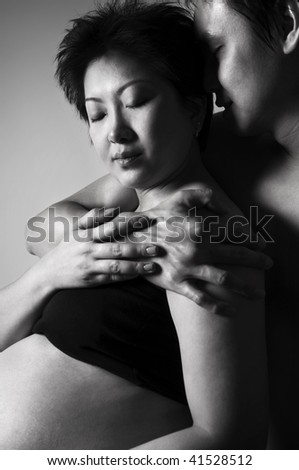 Passionate couple. Asian couple, 8 months pregnant women in low key.